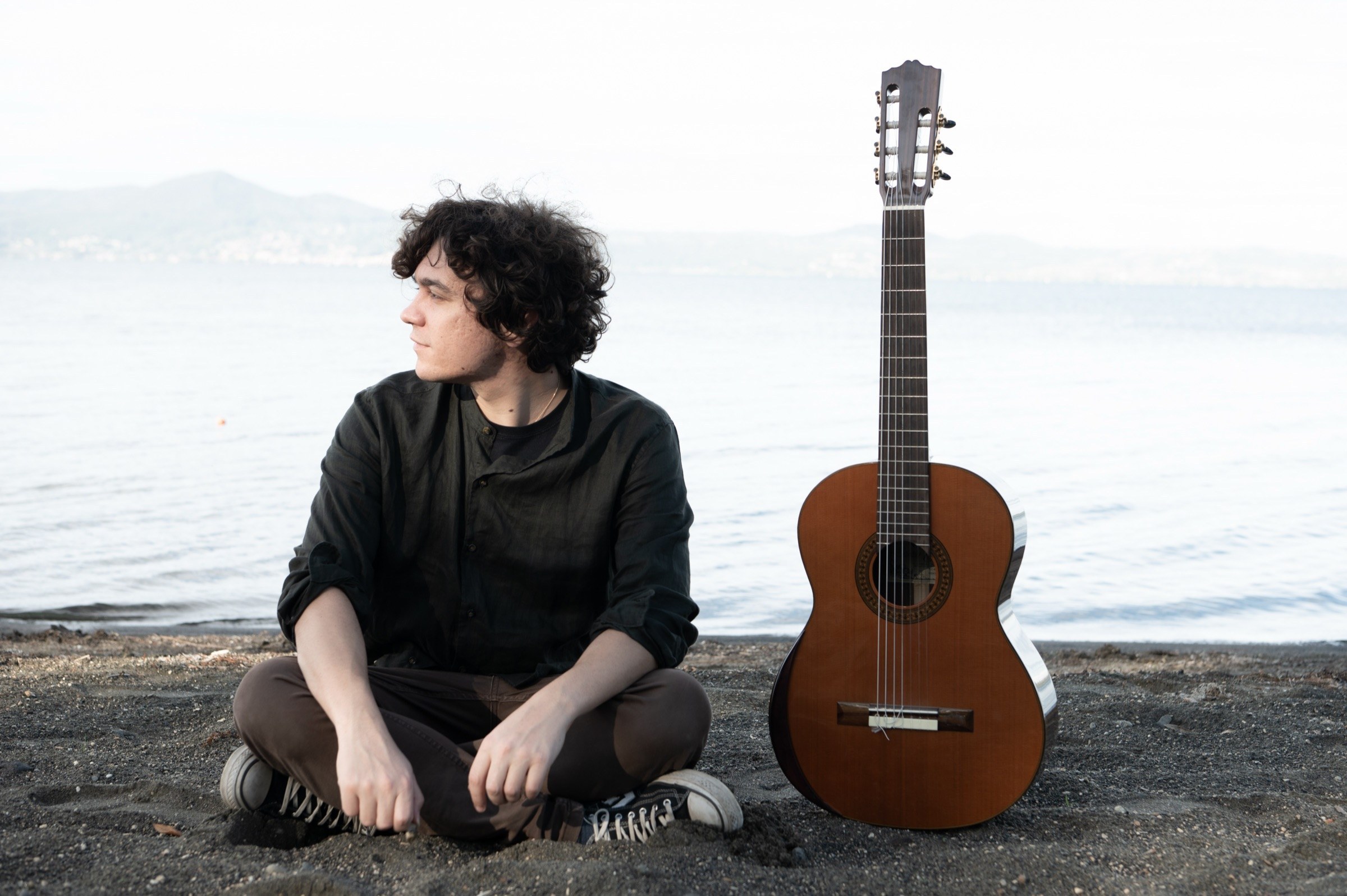 Emanuele Schillaci with his guitar by the sea